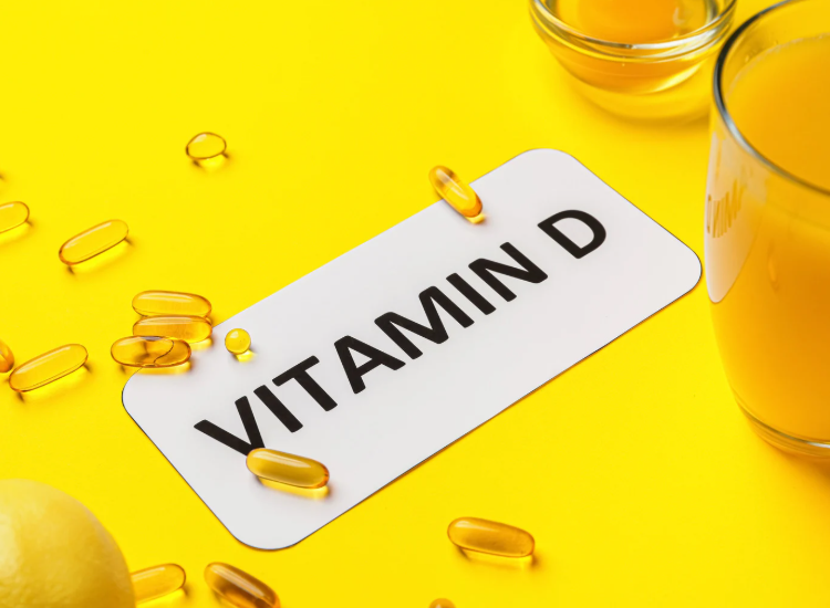 Integratore vitamina D con capsule molli su sfondo giallo e succo d’arancia